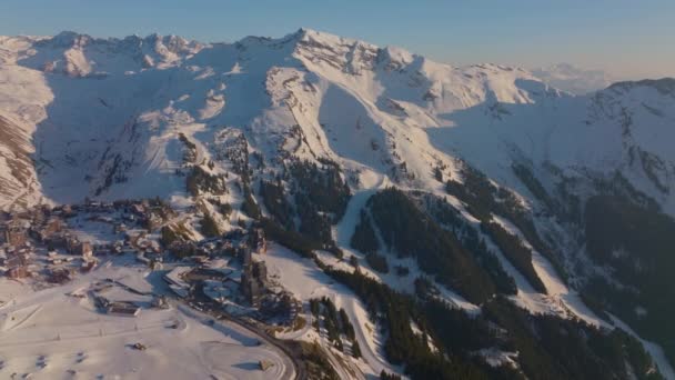 Nappali Drónfelvétel Havas Hegytetőről Alpesi Fákkal Síközponttal — Stock videók