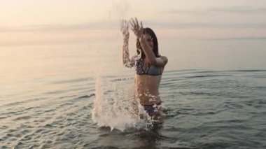 Kameraya doğru su sıçratan bir gencin ön görüntüsü