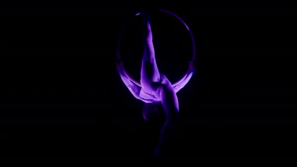 一个女人背向平衡的全景镜头在黑暗的背景下裂开 紫色的聚光灯聚焦在她身上 — 图库视频影像