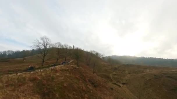 Беспилотник Совершает Воздушные Манёвры Над Людьми Пути Холму Облачный День — стоковое видео