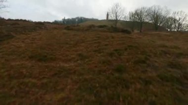 Alçaktan uçan bir dron Himmelbjerget kulesinin üzerinde bulutlu bir gökyüzünün altında aşağıdaki kalabalığın ve yakınlardaki denizin mükemmel manzarasıyla yarışır.