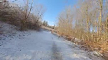 Hızlı hava manzarası karlı zeminde ve gündüz vakti bir adamın üzerinde uçuyor.