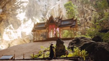 Kuha Karuhas köşkünün yakınındaki kayalık merdivenlere doğru yürüyen bir kadının geniş bir görüntüsü.