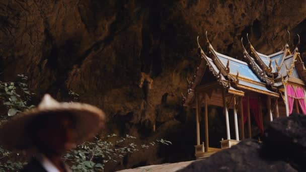 空也中本洞窟の大きな岩の近くを歩く 着物と竹の帽子を身に着けている女性とKuha Karuhasパビリオンの交互に焦点を当てたショット — ストック動画