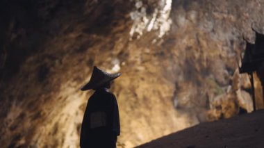 Kuha Karuhas köşküne bakan kimono ve bambu şapkalı bir kadının orta boy fotoğrafı.