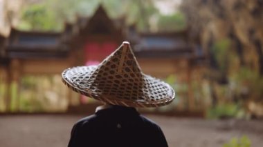 Kimono ve bambu şapkalı bir kadının arkadan görünüşü bulanık altın, mavi ve yeşil Kuha Karuhas köşküne karşı sol ve sağ yöne bakıyor.