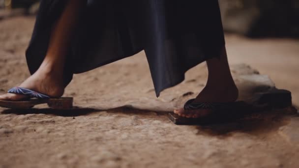Bir Mağaranın Kayalık Zemininde Geleneksel Ahşap Sandaletlerle Yürüyen Bir Kadının — Stok video
