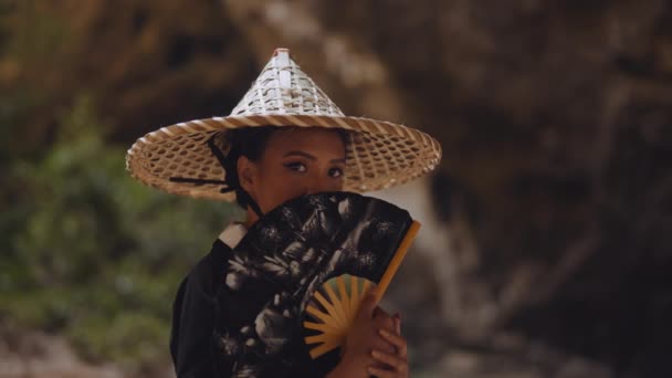 Kimonolu Bambu Şapkalı Bir Kadın Kameraya Bakarken Ağzını Bir Vantilatörüyle — Stok video