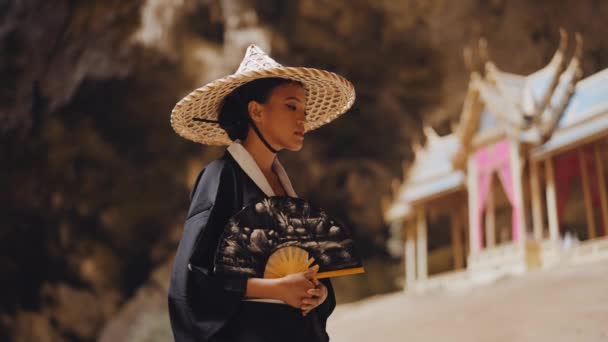 Una Mujer Kimono Sombrero Bambú Agitando Abanico Mano Mira Aleja — Vídeo de stock