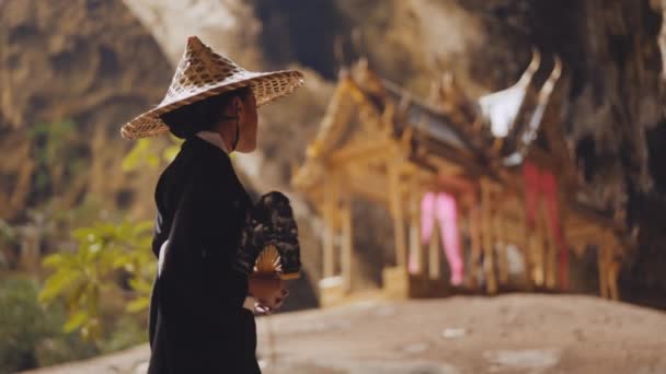 一位身穿和服的妇女一边走着一边挥动着她的手扇 用模糊的库哈库哈库哈亭子触摸着她的竹帽 — 图库视频影像