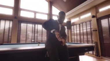 Orta boy, kollarını sağa doğru sallayarak dans eden bir adamın görüntüsü ve sonrasında elbisesini düzeltir.