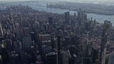 Gündüz vakti Manhattan şehri, Doğu nehri ve Hudson nehrinin helikopterinden havadan sola doğru görüntüler çekiliyor.