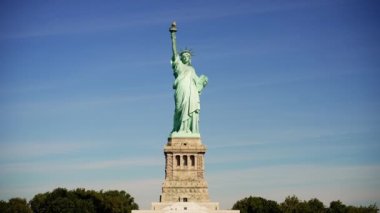 New York limanındaki Liberty Adası 'nda bulunan güneşli Özgürlük Heykeli' nin bir fotoğrafı.