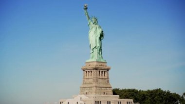 New York limanındaki Liberty Island 'da bulunan açık mavi gökyüzüne karşı Özgürlük Anıtı' nın geniş bir görüntüsü.