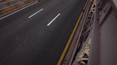 Brooklyn Köprüsü 'nden gündüz vakti birden fazla arabanın geçtiğini gösteren eğik bir çekim.