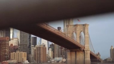 New York 'ta bulunan Brooklyn Köprüsü' nü ve kulesini gösteren bulanık çelik parmaklıklardan yukarı doğru bir eğim atışı.