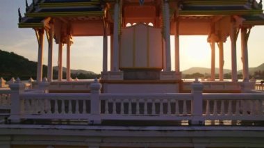 Pan çekimi Tayland 'da gün batımında kuşlarla Khao Tao Gölü Tapınağı' nın solundan sağa hareket ediyor. 