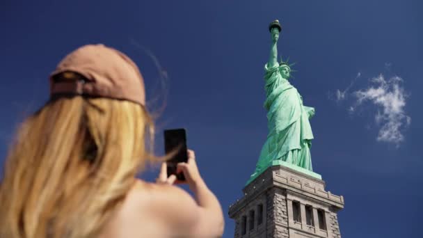 位于纽约市自由岛的一个女子用手机拍摄自由女神像的低角度照片 — 图库视频影像