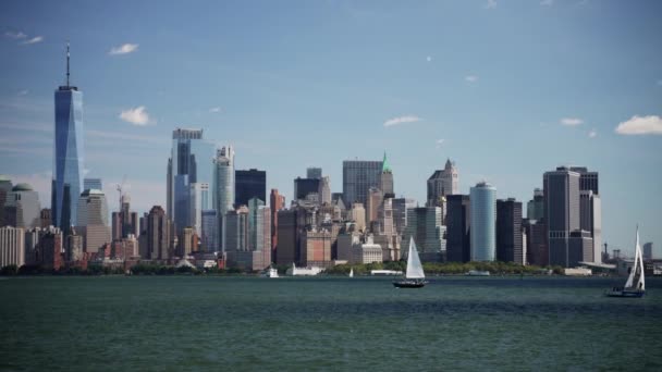 右から左に移動するパンショット 昼間の帆船と川からニューヨーク市のスカイラインの景色を表示します — ストック動画