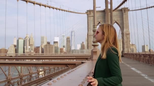 Відео Жінки Зеленому Пальто Червоних Сонцезахисних Окулярах Бруклінському Мості Дивиться — стокове відео