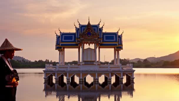 在泰国 一幅高渡湖寺庙的照片仍在拍摄 一名妇女在日落时走进现场 站在原处 — 图库视频影像