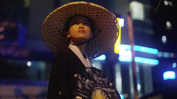 Woman Wearing Kimono Bamboo Hat Holding Hand Fan Looking Upwards — Vídeos de Stock