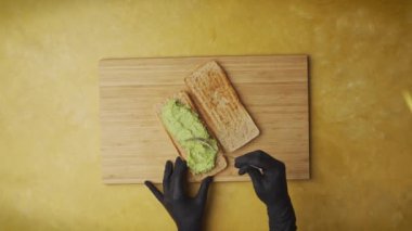Top view shot of a poke sandwich being prepared and sliced on a yellow table