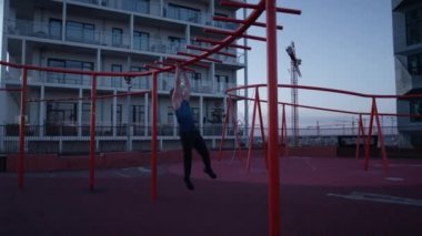 A video of a man doing a calisthenic exercise on the monkey bars