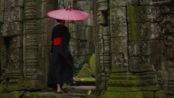 着物を着た女性の背中を見せてくれるフルショットで 昼間はカンボジアの寺院の華やかな入り口に入っていきます — ストック動画