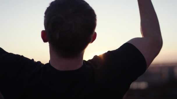 Back View Man Doing Pull Ups While Facing Sunset Rooftop — Stockvideo