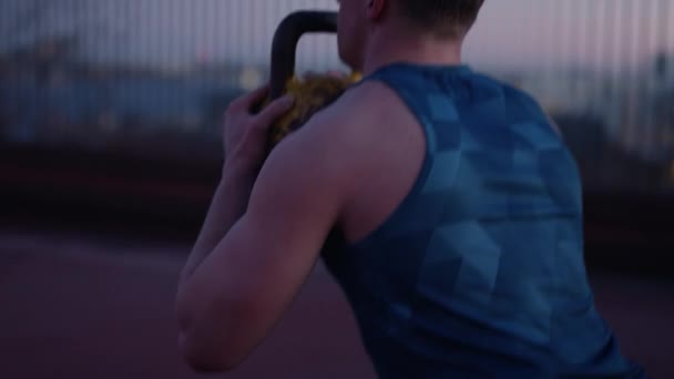 Back View Man Doing Kettlebell Squats Rooftop Sunset — Video