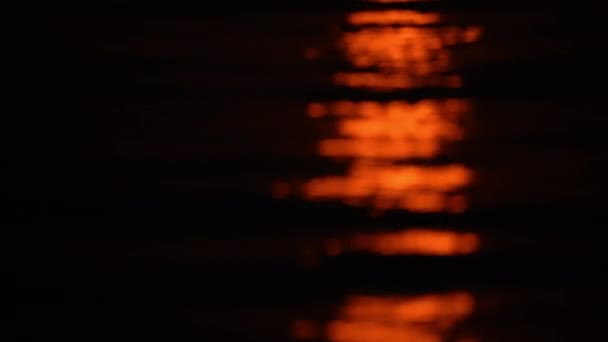 Close Shot Tilting Upwards Showing Reddish Moonlight Reflecting Water — Αρχείο Βίντεο