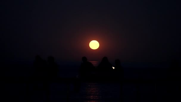 Backview Showing Silhouettes People Relaxing Seaside Jetty Full Moon — Vídeos de Stock