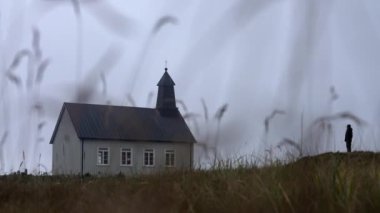 Man standing outside and staring at Strandarkirkja church in Iceland