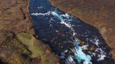 Aerial view of the beautiful river of Bruarfoss waterfall and the green landscape surrounding it