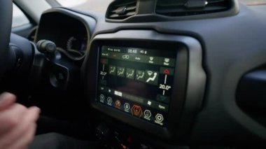 A close-up shot of a person activating the GPS on the car's infotainment system