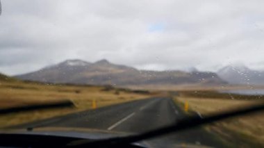 A car wiping its windshield to show the magnificent view of the mountain landscape in Iceland during daytime