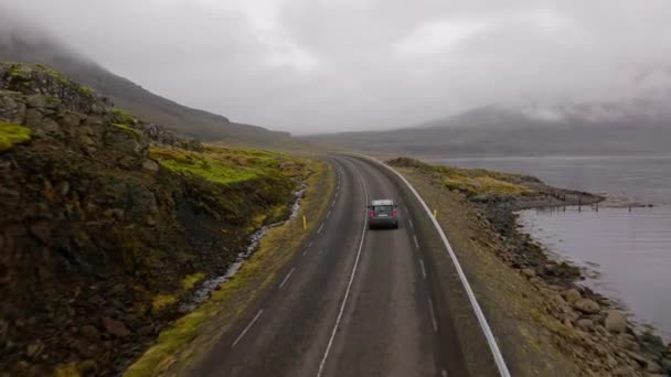 Aerial Shot Grey Car Travelling Foggy Winding Road River Right — Stockvideo