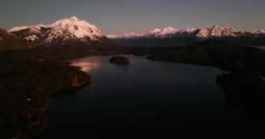 A wide drone flight over the Nahuel Huapi lake with a view of Tronador mountain at Bariloche, Argentina during dawn