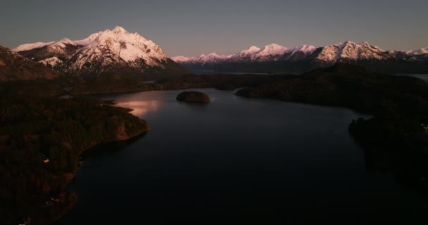 夜明けの間にアルゼンチンのバリローチェにあるTronador山の景色を望むNahuel Huapi湖の上の幅広いドローン飛行 — ストック動画
