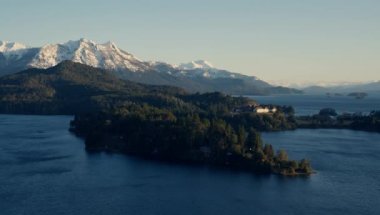 A still shot of the Nahuel Huapi park's lake, forest, and snow-capped mountain range at Bariloche, Argentina during daytime