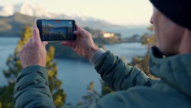A video of a man recording a video of the view of Nahuel Huapi lake at Bariloche, Argentina during daytime