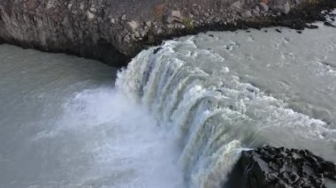 Aerial shot of Thjofafoss waterfall's cascading waters and rocky riverside