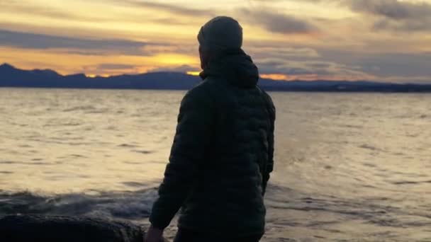 在阿根廷巴里洛切 一个男子在地平线上观看日出前的海浪的背影 — 图库视频影像