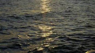 Güneş doğarken Arjantin 'in Bariloche kentindeki bir göle yansıyan dalgaların yakın plan çekimi.