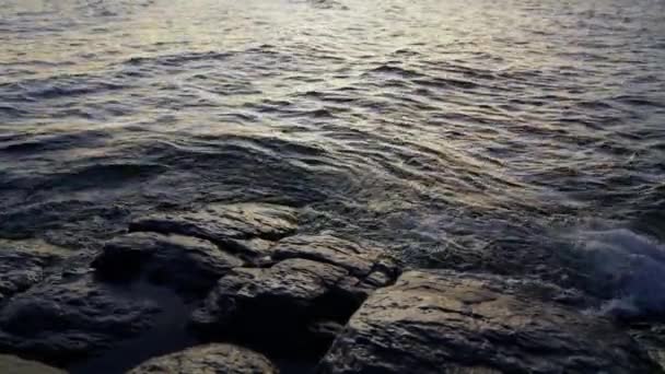 충격파가 일출시에 아르헨티나 로체의 바위가 호숫가로 흐르고 — 비디오