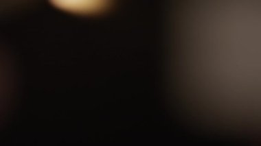 A close-up shot of a blurry burning matchstick that slowly goes into focus against a dark background