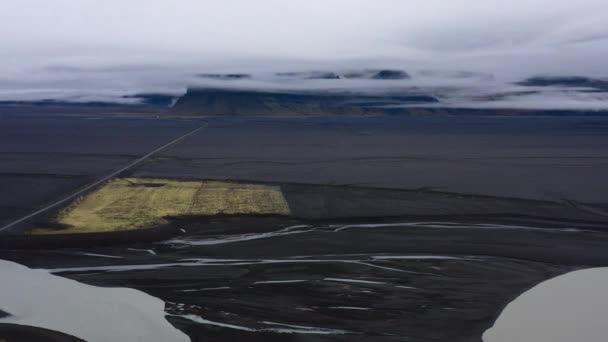 昼間にアイスランドに位置する緑の苔で覆われたジョクルサロン氷河ラグーンと溶岩平野の美しい風景を示す傾斜後退ショット — ストック動画