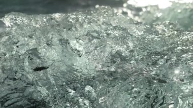 Close-up shot showing the sunlight reflecting on the surface of one of the many pieces of icebergs on Diamond Beach's coastline