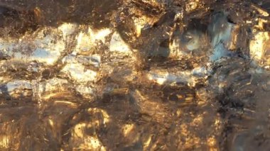 A close-up of a glistening iceberg reflecting the sun's golden rays